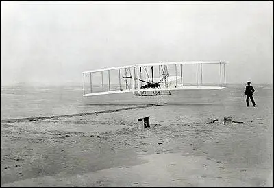 Orville Wright, watched by Wilbur Wright, pilots the Flyer in its first flight on 17th December, 1903