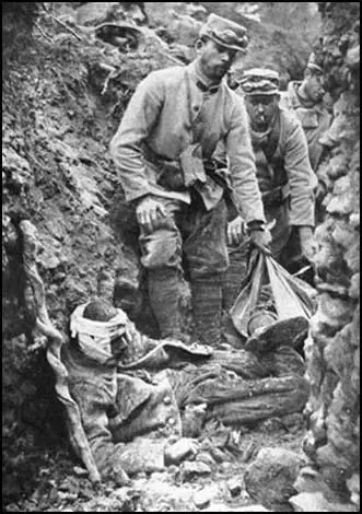 French soldiers try to move a wounded man alonga communication trench on the Western Front.