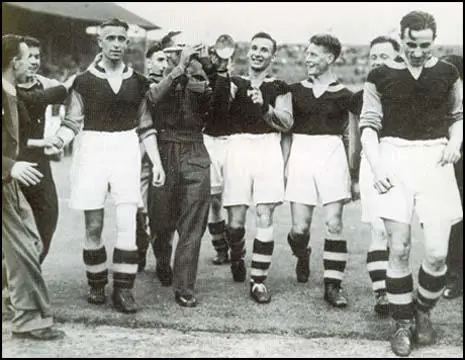 The West Ham team celebrate victory in the 1940 War Cup Final. Left to right,Charlie Bicknell, Norman Corbett (in uniform), Ted Fenton, (unknown) and Len Goulden.