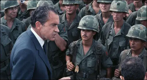 Richard Nixon inspects troops fighting in the Vietnam War.