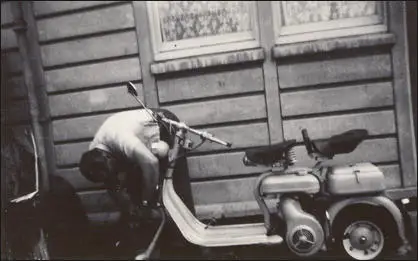 John (Ted) Simkin, working on his motor scooter in the backyard of his house in Audley Gardens.