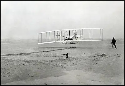 Orville Wright, watched by Wilbur Wright, pilotsthe Flyer in its first flight on 17th December, 1903
